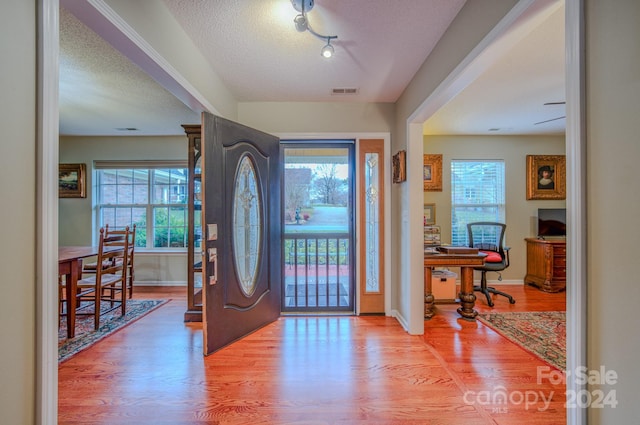 entryway featuring wood-type flooring and a textured ceiling