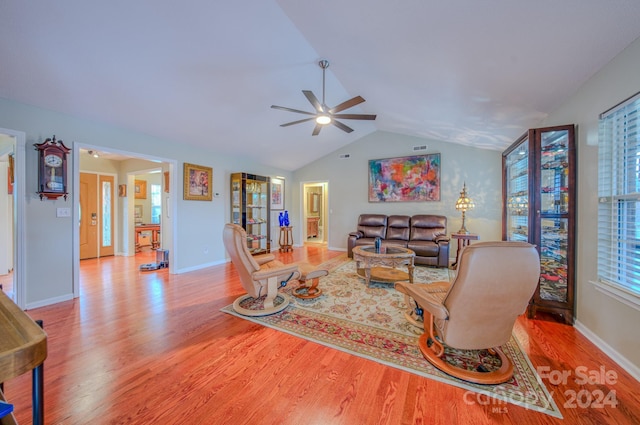 living room with ceiling fan, light hardwood / wood-style flooring, and lofted ceiling