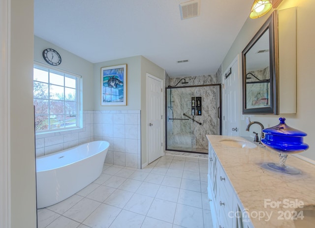 bathroom featuring vanity, tile walls, and plus walk in shower