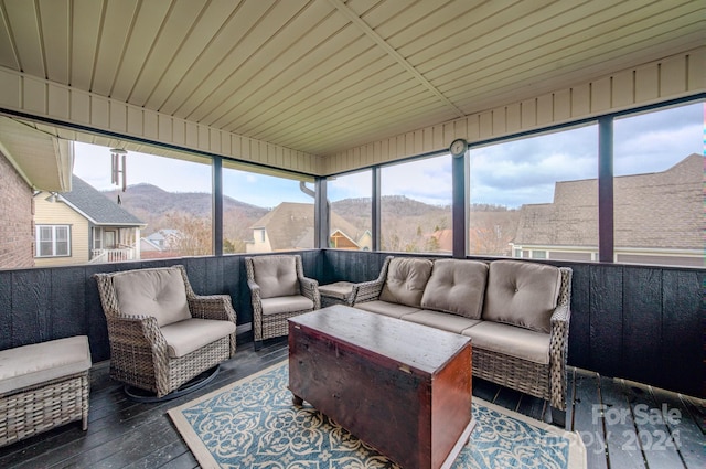 sunroom / solarium with a mountain view, plenty of natural light, and wood ceiling