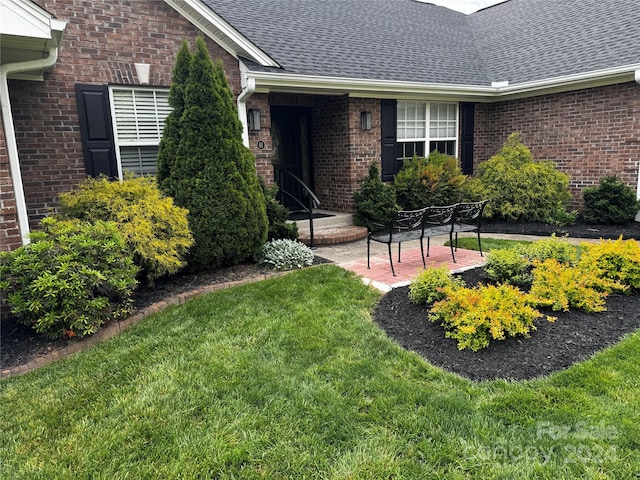 doorway to property with a patio area and a lawn