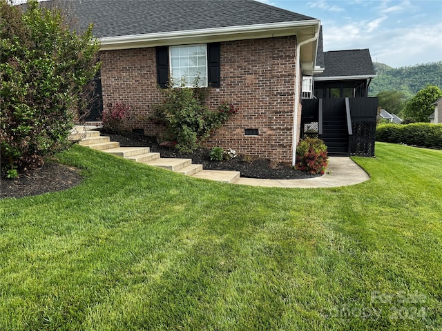 view of side of property with a lawn and a sunroom