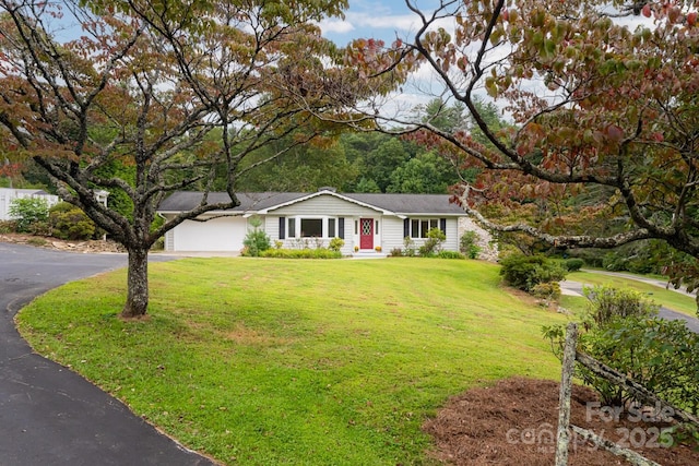 ranch-style house featuring a garage and a front yard