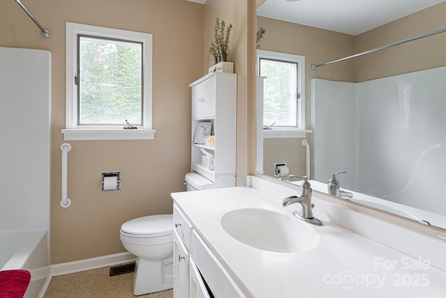 bathroom featuring toilet, plenty of natural light, and vanity