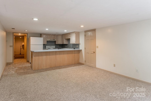 kitchen featuring light brown cabinets, light carpet, white fridge, and tasteful backsplash