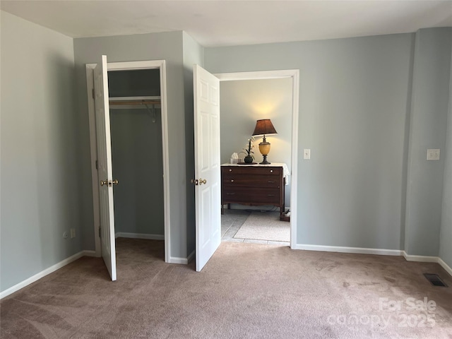 unfurnished bedroom featuring a closet and light colored carpet