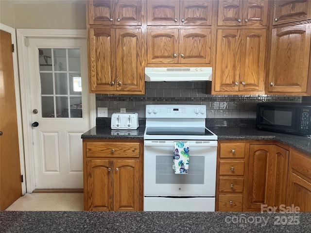 kitchen with tasteful backsplash, white range with electric cooktop, and dark stone counters