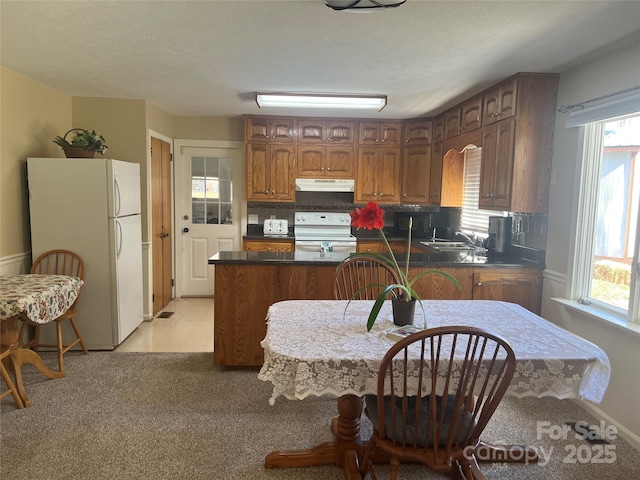 kitchen with sink, kitchen peninsula, and white appliances