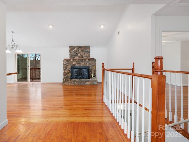 unfurnished living room with a notable chandelier, light hardwood / wood-style floors, crown molding, and a fireplace