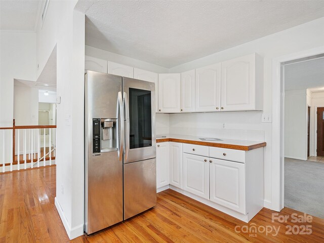 kitchen with white cabinets, stainless steel fridge, and light wood-type flooring