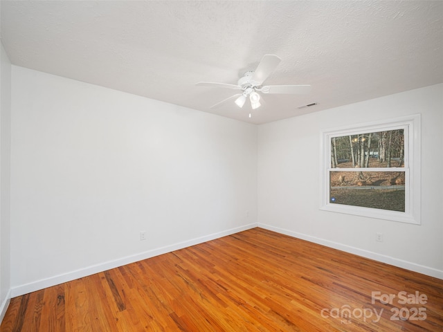 empty room featuring hardwood / wood-style floors, ceiling fan, and a textured ceiling