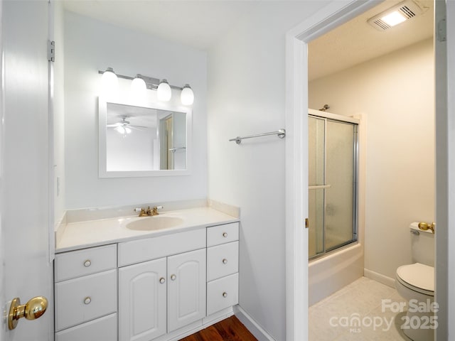 full bathroom featuring ceiling fan, enclosed tub / shower combo, tile patterned floors, toilet, and vanity