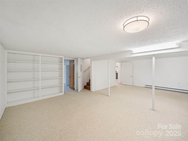 basement with baseboard heating, built in features, carpet, and a textured ceiling