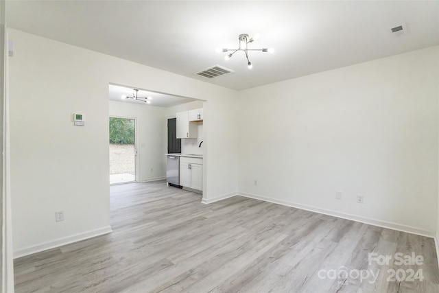 unfurnished living room featuring sink, light hardwood / wood-style floors, and a notable chandelier