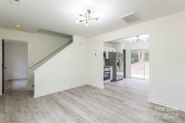 unfurnished living room featuring a chandelier and light hardwood / wood-style flooring