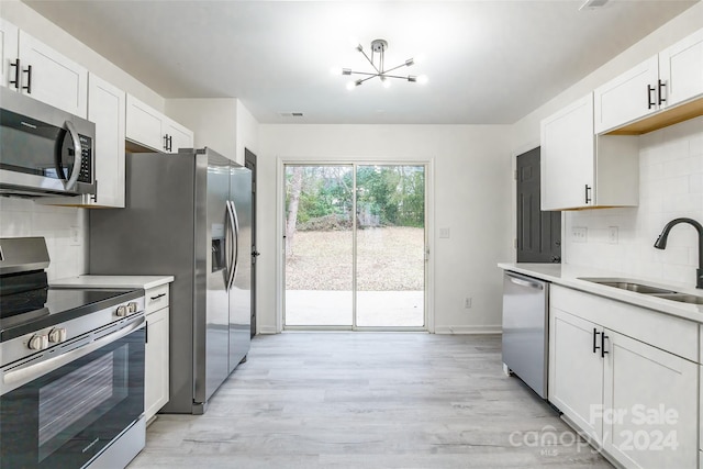 kitchen with decorative backsplash, white cabinetry, sink, and appliances with stainless steel finishes