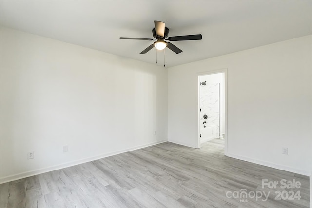 empty room with ceiling fan and light hardwood / wood-style flooring