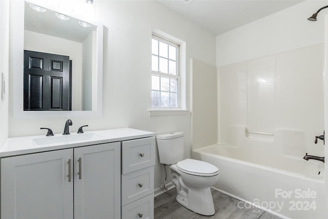 full bathroom featuring hardwood / wood-style floors, vanity, toilet, and shower / bath combination