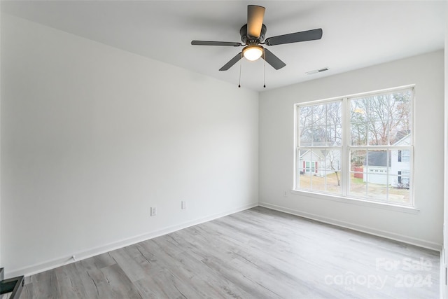 spare room with ceiling fan and light wood-type flooring