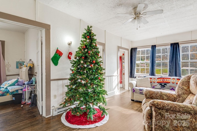 interior space featuring a baseboard heating unit, ceiling fan, a textured ceiling, and hardwood / wood-style flooring