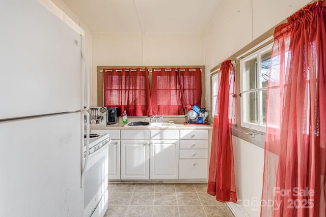 kitchen with white cabinetry, white appliances, and sink