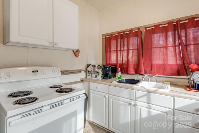 kitchen featuring sink, white cabinetry, and electric stove