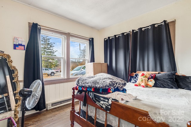 bedroom featuring baseboard heating and hardwood / wood-style flooring