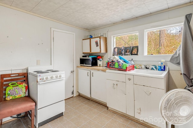 kitchen featuring white cabinetry, gas range gas stove, sink, and ornamental molding