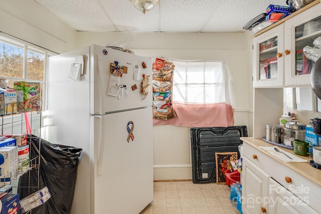 kitchen featuring white cabinets, a paneled ceiling, and white fridge