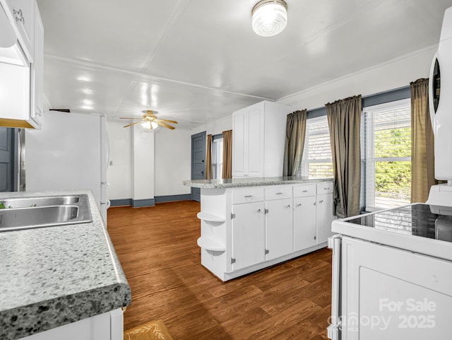 kitchen featuring dark hardwood / wood-style flooring, ceiling fan, white cabinets, a center island, and stainless steel refrigerator