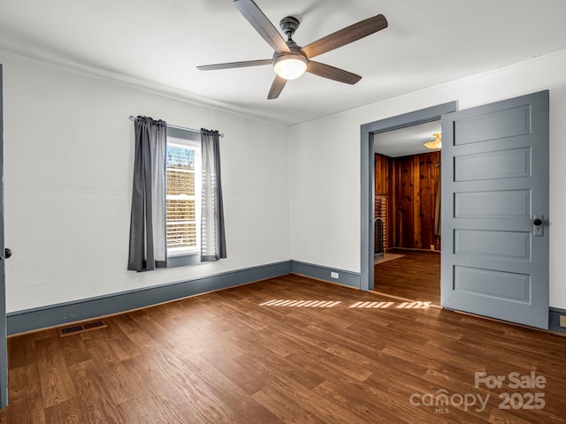 unfurnished room with ceiling fan and dark wood-type flooring