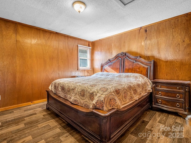 bedroom featuring a textured ceiling, dark wood-type flooring, and wood walls