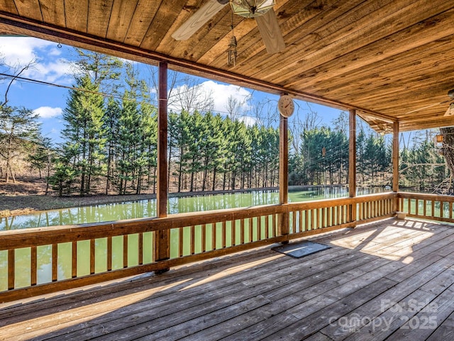 wooden deck with ceiling fan and a water view