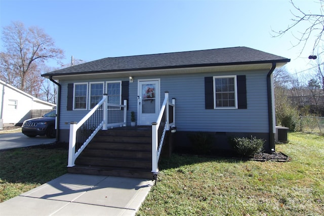 view of front facade with a front yard and cooling unit