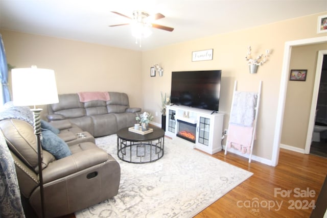 living room featuring wood-type flooring and ceiling fan