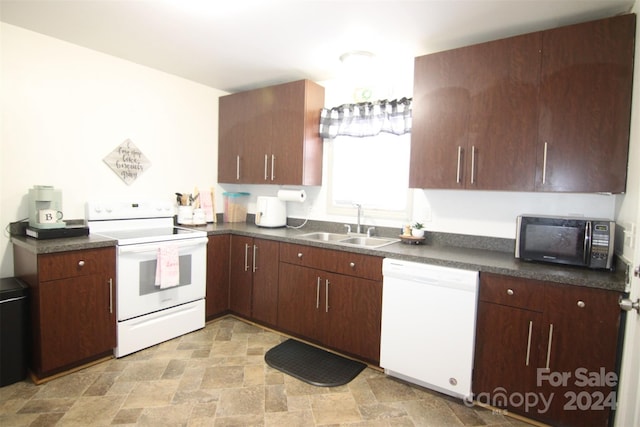 kitchen with dark brown cabinetry, sink, and white appliances