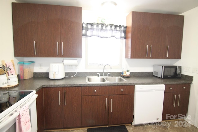 kitchen with tile patterned floors, dishwasher, dark brown cabinetry, and sink