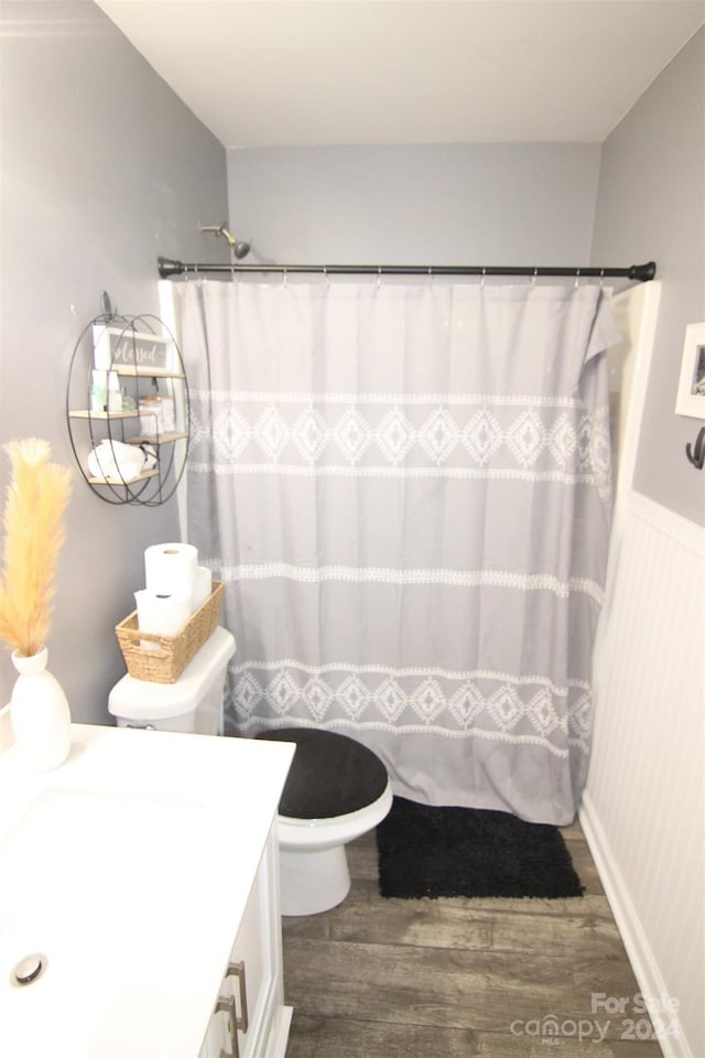 bathroom featuring hardwood / wood-style flooring, vanity, toilet, and a shower with shower curtain