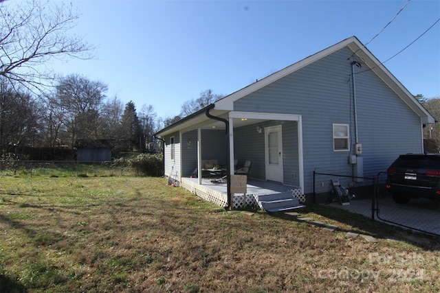 rear view of house featuring a porch and a yard