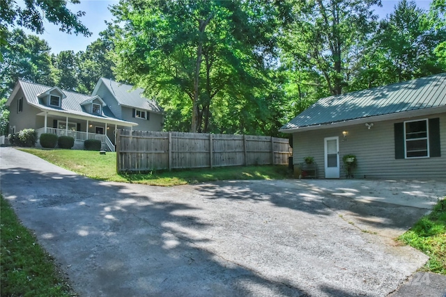 view of side of property with a lawn and covered porch