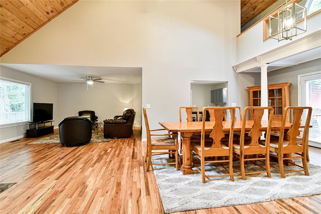 dining room with high vaulted ceiling, light hardwood / wood-style flooring, plenty of natural light, and wooden ceiling