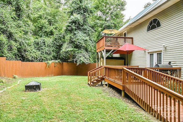 view of yard featuring a wooden deck and a fire pit