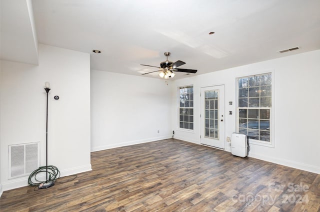 empty room with ceiling fan and dark wood-type flooring