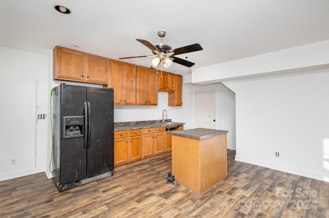 kitchen featuring a center island, black fridge, sink, ceiling fan, and dark hardwood / wood-style flooring