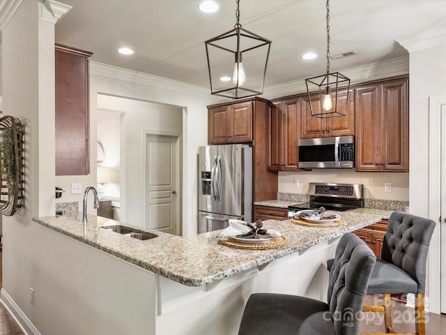 kitchen featuring light stone countertops, kitchen peninsula, decorative light fixtures, a breakfast bar, and appliances with stainless steel finishes