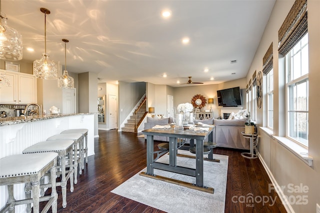 dining room with ceiling fan, dark wood-type flooring, and sink