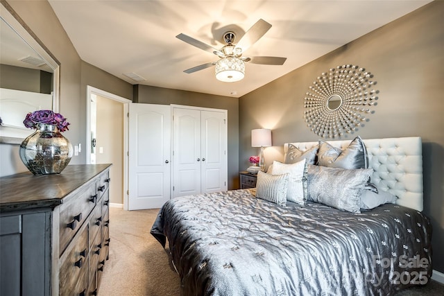 carpeted bedroom featuring a closet and ceiling fan