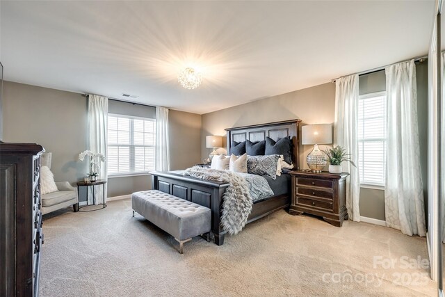 bedroom featuring multiple windows and light colored carpet