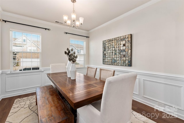 dining area with ornamental molding, a healthy amount of sunlight, and a chandelier