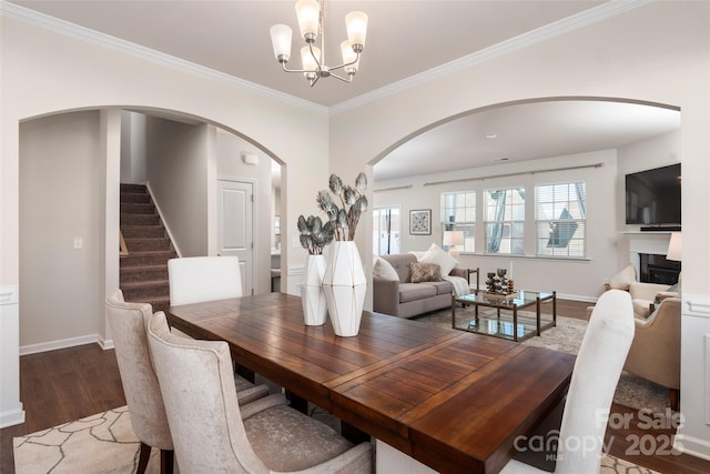 dining room with a notable chandelier, ornamental molding, and dark hardwood / wood-style floors